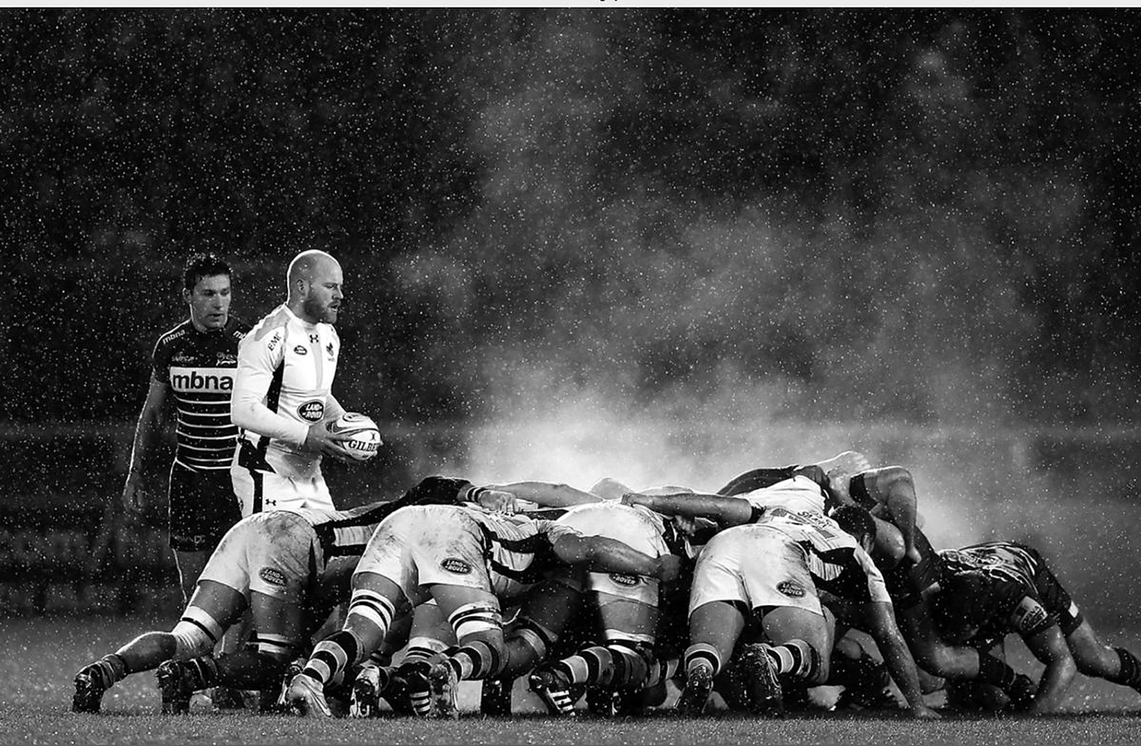 Formación de rugby avanzando en un scrum bajo la lluvia