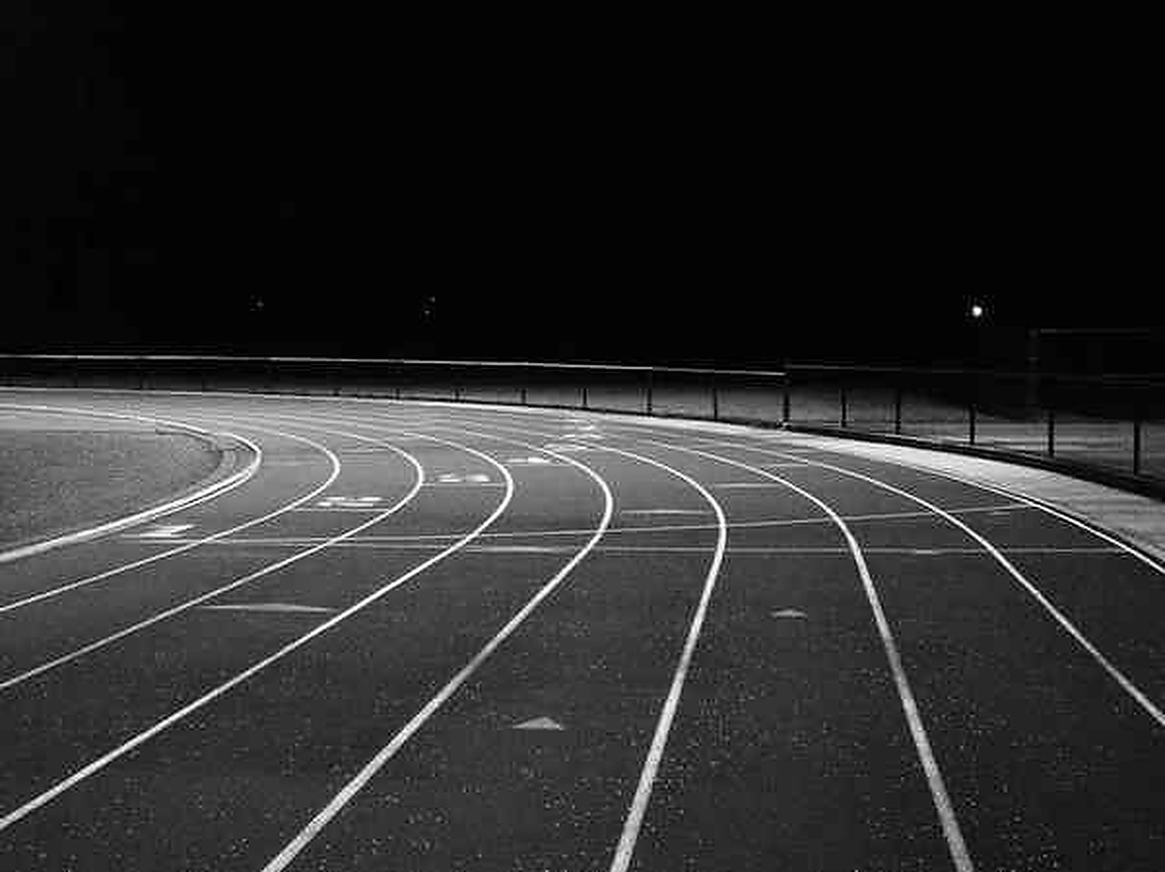 Pista de atletismo vacía iluminada de noche